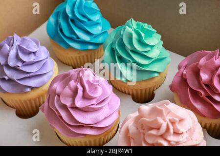 Tasty colorful cupcakes in cardboard box, closeup Stock Photo