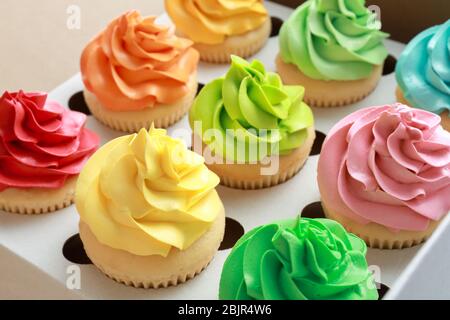 Tasty colorful cupcakes in cardboard box, closeup Stock Photo