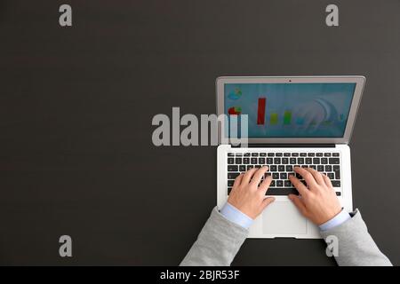 Hands of marketing manager working with laptop on dark background Stock Photo