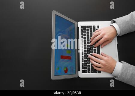 Hands of marketing manager working with laptop on dark background Stock Photo