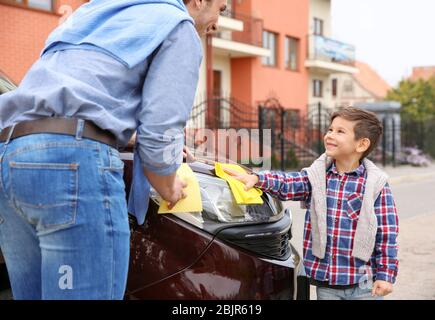 Father and son cleaning car outdoors Stock Photo