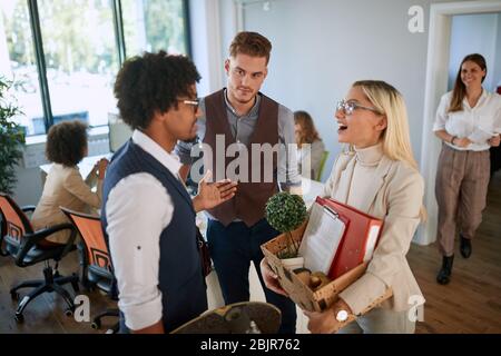 welcoming new young colleagues by group of employees in open space office. casual business concept Stock Photo