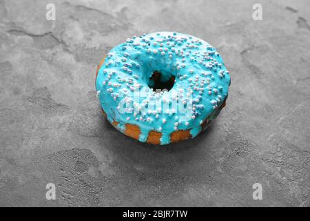 Blue donut with sprinkles on grey background Stock Photo