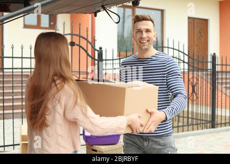 Young couple unloading boxes from their car on moving day Stock Photo