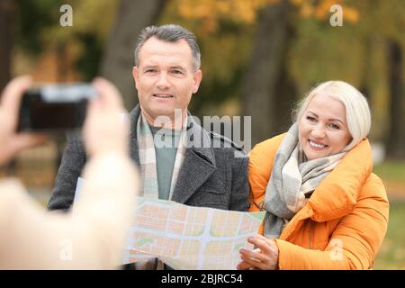 Happy mature couple posing for camera in park Stock Photo