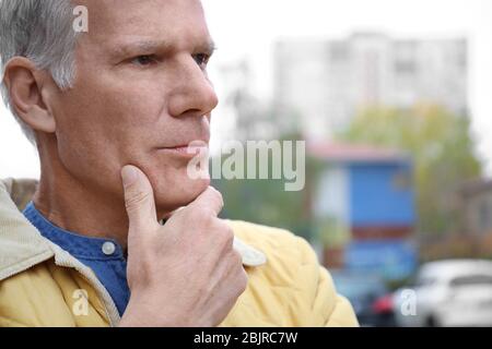 Charismatic thoughtful senior man outdoors Stock Photo