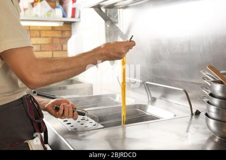 Male chef cooking pasta in restaurant kitchen Stock Photo