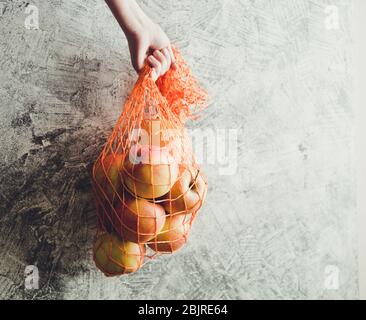 Concept-ecology, nature conservation, no plastic bags. Reusable mesh bag with apples, copy space/ Stock Photo