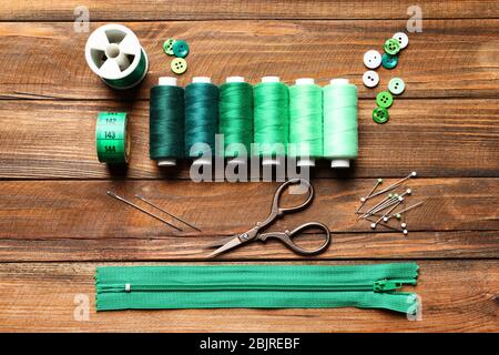 Set of tailoring tools and accessories on wooden background, top view Stock Photo