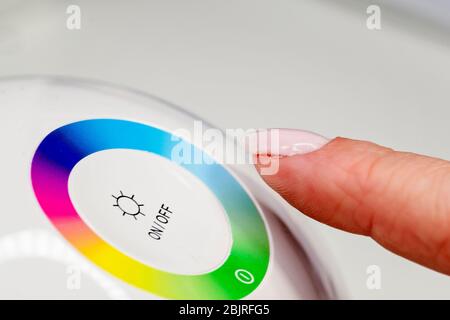 Woman finger turning off the light. Pressing index finger on lighting switch. Energy saving concept. Stock Photo
