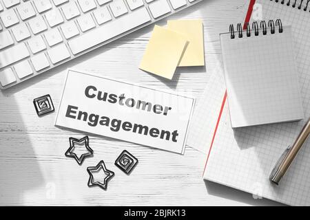 Sheet of paper with text CUSTOMER ENGAGEMENT on office table Stock Photo