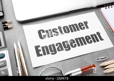 Sheet of paper with text CUSTOMER ENGAGEMENT on office table Stock Photo