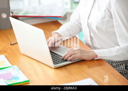 Young woman working with laptop in office, closeup Stock Photo