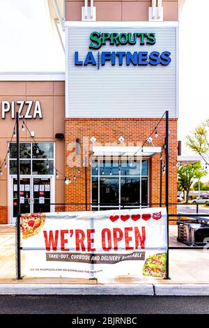 Herndon, USA - April 27, 2020: Strip mall plaza on street in Virginia Fairfax County with sign for open pizza restaurant for take-out curbside and del Stock Photo