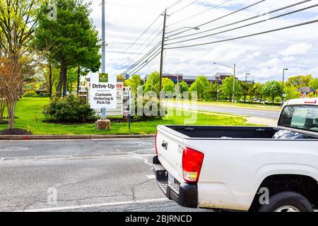 Herndon, USA - April 27, 2020: Virginia Fairfax County road street with sign for open Panera restaurant for take-out curbside during coronavirus Covid Stock Photo