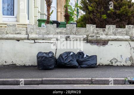 black bin bags full of rubbish on a street or pavement Stock Photo