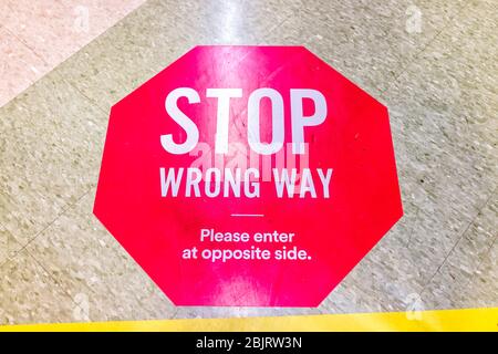 Red warning direction stop sign text for entering wrong way in store aisle during covid-19 coronavirus outbreak with nobody in USA Stock Photo