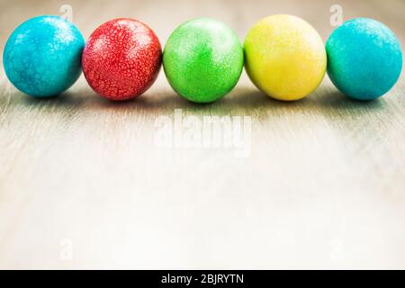 Colorful Easter egg border on white wooden background flat lay Stock Photo
