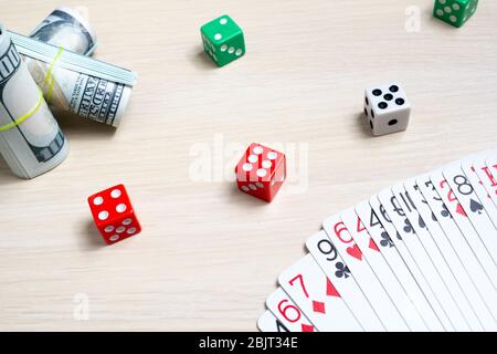 money dollars dice playing cards gambling on a light wooden table Stock Photo
