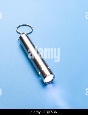 Small flashlight on a blue background Stock Photo