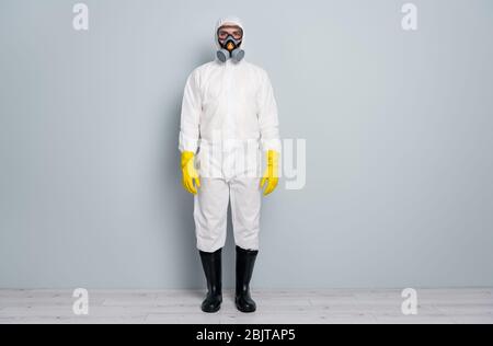 Full length photo of professional guy disinfectant watch public places clean disinfection wear white hazmat protective suit goggles mask gloves