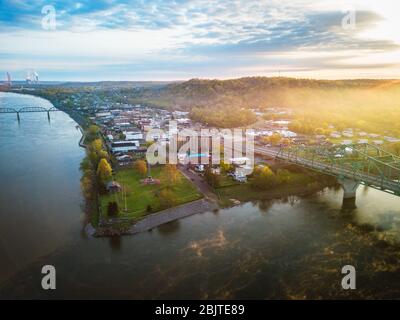 The rising sun casts its glow over the town of Point Pleasant West Virginia viewed from up high where the two rivers of the Kanawha and Ohio meet. Stock Photo