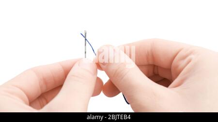 Woman threading needle on white background, closeup Stock Photo