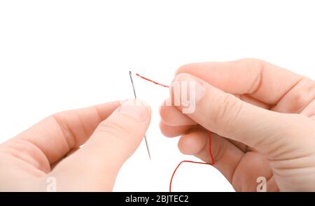 Woman threading needle on white background, closeup Stock Photo