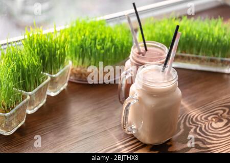 Mason jars with protein shakes on window sill in sport bar Stock Photo
