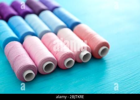 Set of color sewing threads on wooden background Stock Photo