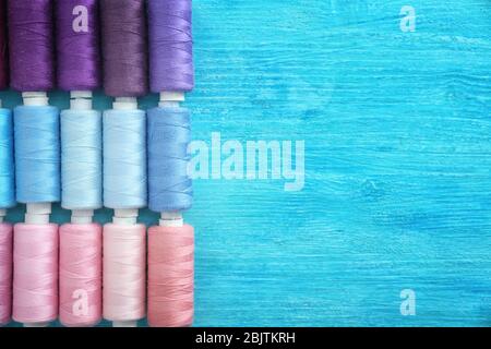 Set of color sewing threads on wooden background Stock Photo