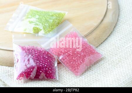 Colorful beads on a wooden surface. Various of shapes and colors to make jewelry Stock Photo