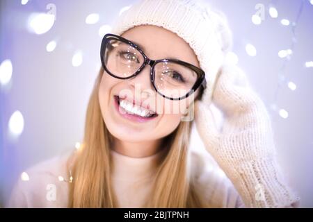Happy woman in hat against blurred lights Stock Photo