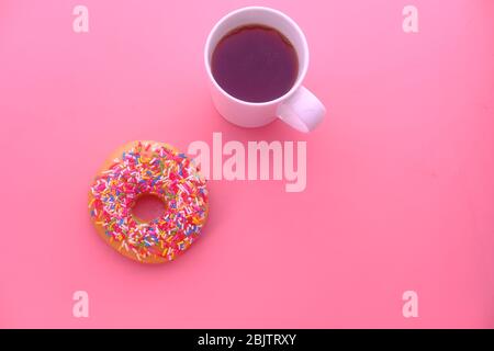 Cup of coffee and donuts on a pink background. Stock Photo