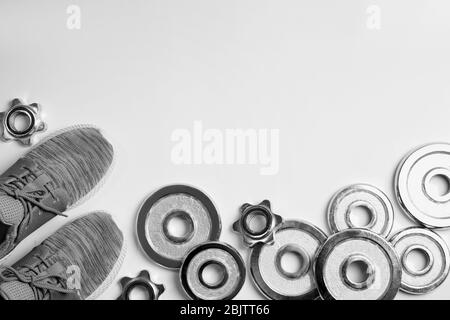 Weight plates, sneakers and blank space for gym exercise plan on white background. Flat lay composition Stock Photo