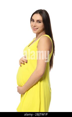 Beautiful pregnant woman in yellow dress holding hands on belly against white background Stock Photo