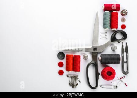 Composition with sewing threads, scissors and accessories on white background, top view Stock Photo