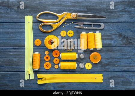 Composition with sewing threads and accessories on wooden background, top view Stock Photo