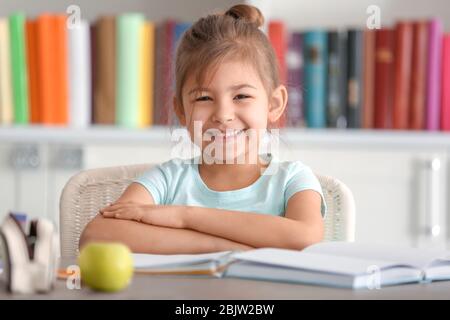 Cute little girl doing homework indoors Stock Photo