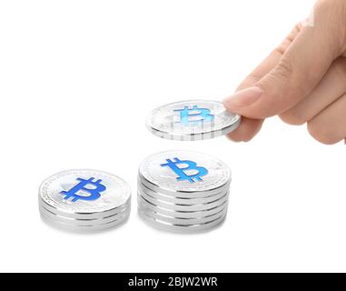 Female hand stacking up silver bitcoins on white background Stock Photo