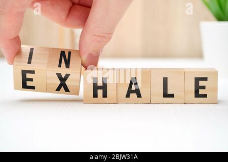 Abstract selection of inhale exhale phrases on wooden blocks. Close up. Stock Photo