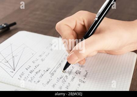 Woman doing homework in exercise book, closeup Stock Photo