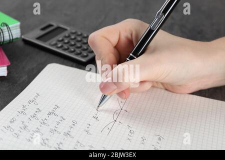 Woman doing homework in exercise book, closeup Stock Photo