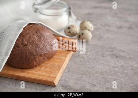 Raw dough covered with towel on table Stock Photo