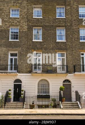 LONDON, ENGLAND - JULY 2018: Townhouses on a street in central London Stock Photo