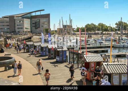 CARDIFF BAY, CARDIFF, WALES  - JULY 2018: Wide angle view of the harbour side walk on the waterfront in Cardiff Bay with boats in the background. Stock Photo