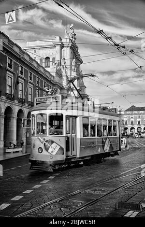 The sun sets on a trolley as it moves through the Praca do Comericio of Lisbon, Portugal Stock Photo