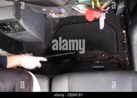 Female hands using vacuum cleaner to clean a car. Top view Stock Photo