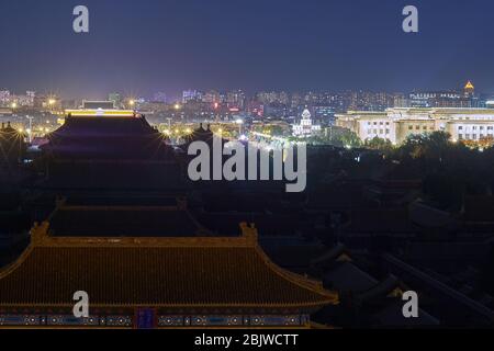 Beijing / China - October 10th 2018: Downtown Beijing with roofs of Forbidden City and illuminated National People Congress (Parliament of China)