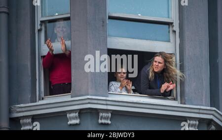 Brighton UK 30th April 2020 - Residents in Kemp Town Brighton take part in the  Clap For Our Carers as they applaud NHS staff and key workers on a windy evening as the country thanks them for their efforts in the battle against coronavirus COVID-19   : Credit Simon Dack / Alamy Live News Stock Photo